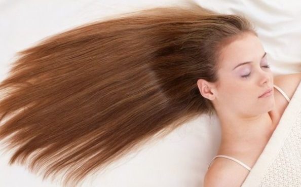a girl with hair laid out to sleep with hair extensions. 